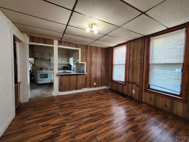 312 Richmond Ave Unit 314, Syracuse, NY 13204 - unfurnished living room featuring a paneled ceiling, dark wood-style flooring, and wood walls