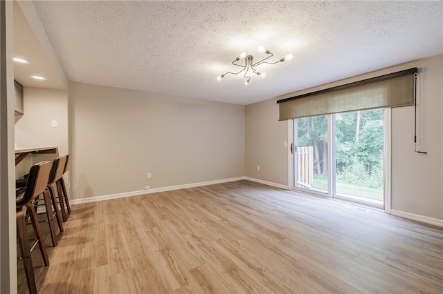 134 Jordache Ln, Ogden, NY 14559 - unfurnished living room with a textured ceiling, a chandelier, light wood-style floors, and recessed lighting