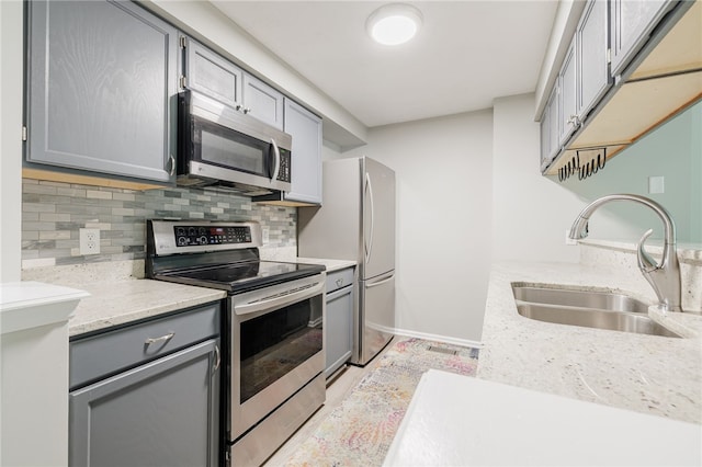 134 Jordache Ln, Ogden, NY 14559 - kitchen with stainless steel appliances, gray cabinets, decorative backsplash, and light stone counters