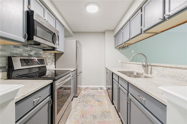 134 Jordache Ln, Ogden, NY 14559 - kitchen featuring stainless steel appliances, gray cabinetry, decorative backsplash, and light stone counters