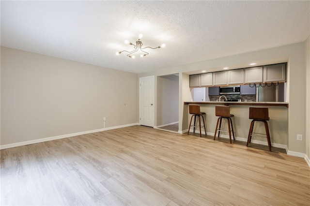 134 Jordache Ln, Ogden, NY 14559 - living area featuring a chandelier, light wood-style floors, and a textured ceiling