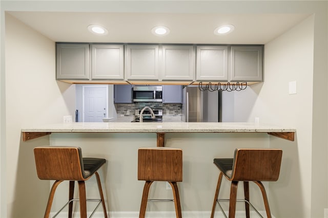 134 Jordache Ln, Ogden, NY 14559 - kitchen with gray cabinets, stainless steel appliances, decorative backsplash, a peninsula, and recessed lighting