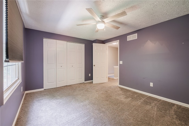 134 Jordache Ln, Ogden, NY 14559 - unfurnished bedroom featuring carpet flooring, a closet, a textured ceiling, and a ceiling fan