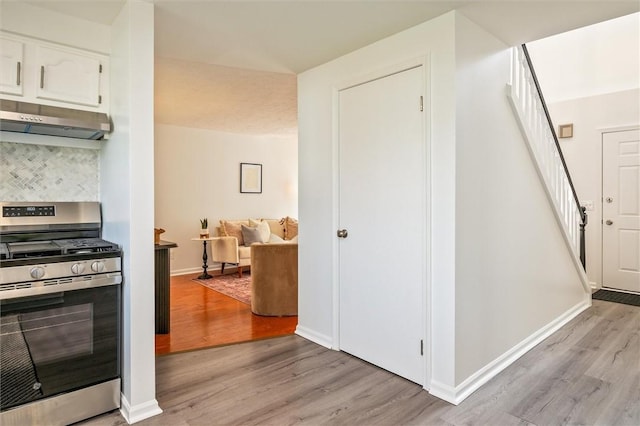 45 Hazel Bark, Gates, NY 14606 - kitchen with stainless steel range with gas cooktop, under cabinet range hood, light wood-style floors, backsplash, and white cabinets