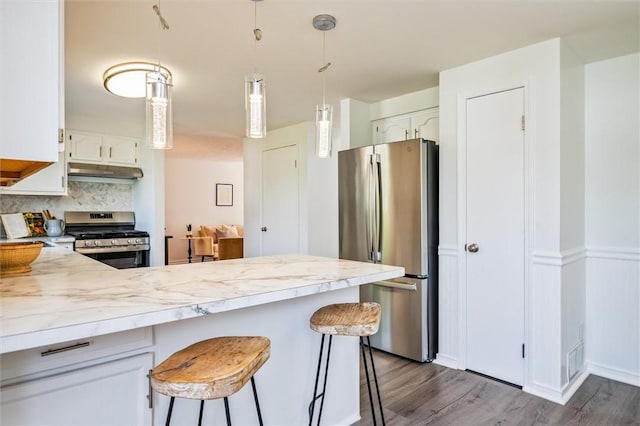45 Hazel Bark, Gates, NY 14606 - kitchen with stainless steel appliances, a peninsula, under cabinet range hood, light countertops, and wood finished floors