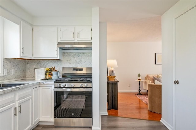 45 Hazel Bark, Gates, NY 14606 - kitchen with stainless steel gas stove, under cabinet range hood, light countertops, white cabinetry, and tasteful backsplash