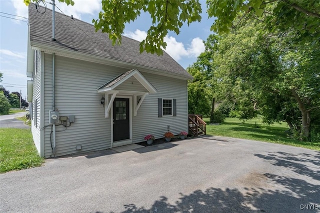 15243 Factory St, Clayton, NY 13632 - view of front of home with a shingled roof and a front lawn