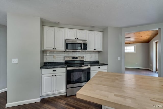 15243 Factory St, Clayton, NY 13632 - kitchen featuring appliances with stainless steel finishes, dark countertops, dark wood-style floors, and white cabinetry