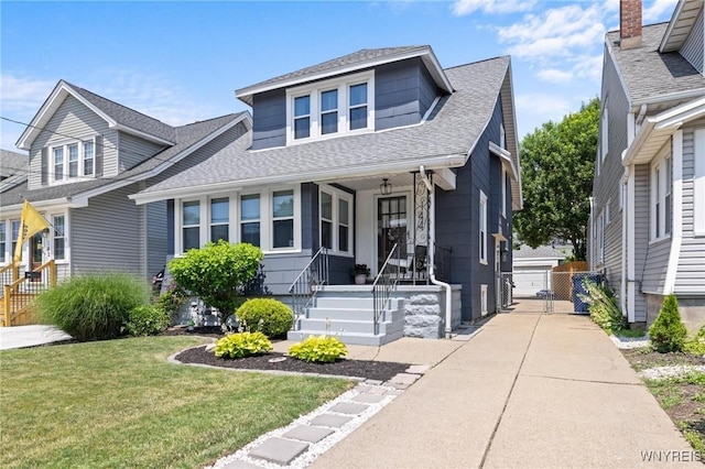 144 Whitfield Ave, Buffalo, NY 14220 - bungalow with roof with shingles, a front yard, a porch, an outdoor structure, and a garage