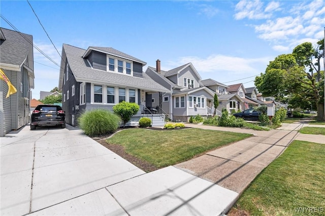 144 Whitfield Ave, Buffalo, NY 14220 - bungalow featuring a front lawn, concrete driveway, a porch, a shingled roof, and a residential view