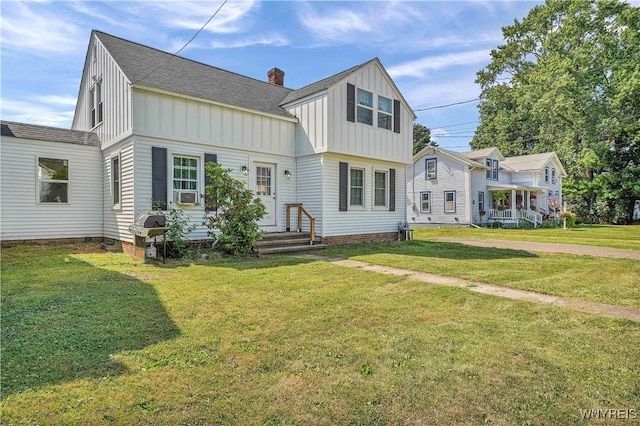 10470 Main St, North Collins, NY 14111 - view of front facade featuring board and batten siding, roof with shingles, a front yard, and a chimney