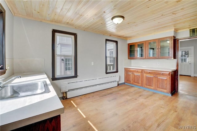 10470 Main St, North Collins, NY 14111 - kitchen featuring baseboard heating, wooden ceiling, light countertops, brown cabinetry, and glass insert cabinets