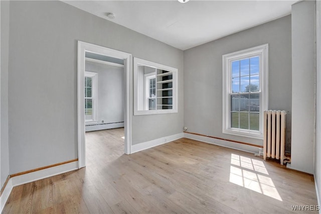 10470 Main St, North Collins, NY 14111 - unfurnished room featuring radiator heating unit, a baseboard radiator, wood finished floors, and a smoke detector