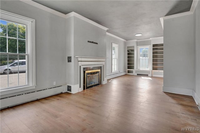 10470 Main St, North Collins, NY 14111 - unfurnished living room with baseboard heating, wood finished floors, built in shelves, a glass covered fireplace, and ornamental molding