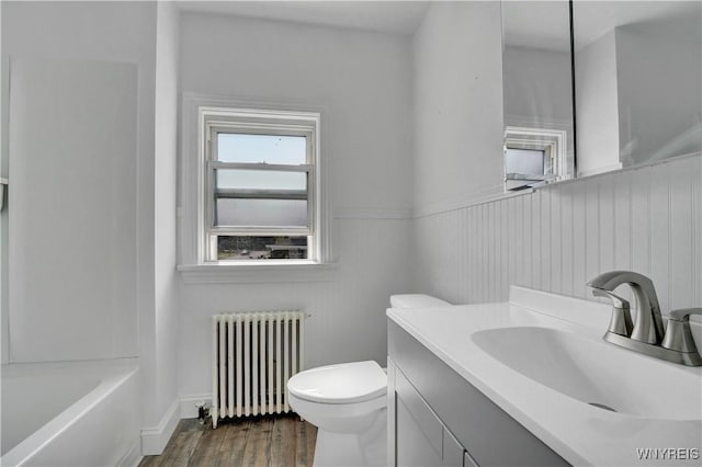 10470 Main St, North Collins, NY 14111 - full bathroom with radiator heating unit, vanity, and wood finished floors