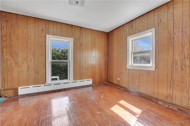 10470 Main St, North Collins, NY 14111 - empty room featuring a baseboard radiator, hardwood / wood-style flooring, and wooden walls