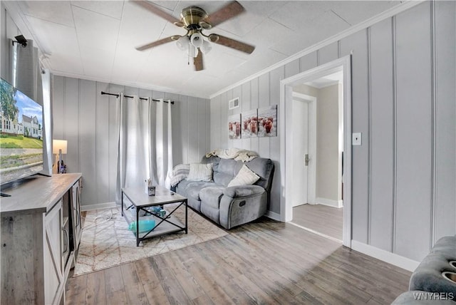 10470 Main St, North Collins, NY 14111 - living room with crown molding, a decorative wall, light wood-style flooring, and ceiling fan