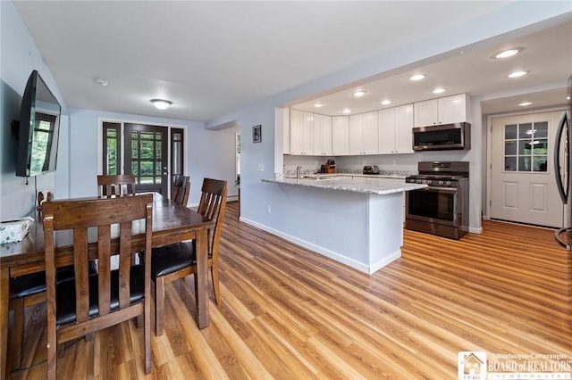 2777 S Roberts Rd, Sheridan, NY 14063 - kitchen with stainless steel appliances, white cabinetry, light wood-style floors, a peninsula, and recessed lighting