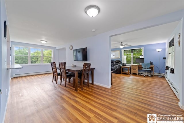 2777 S Roberts Rd, Sheridan, NY 14063 - dining area with baseboard heating, a baseboard radiator, wood finished floors, and a desk