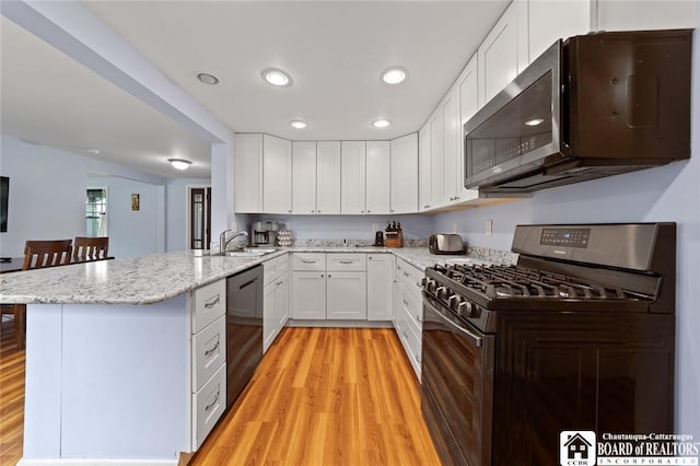 2777 S Roberts Rd, Sheridan, NY 14063 - kitchen featuring stainless steel microwave, black range with gas stovetop, dishwasher, a peninsula, and light wood-type flooring
