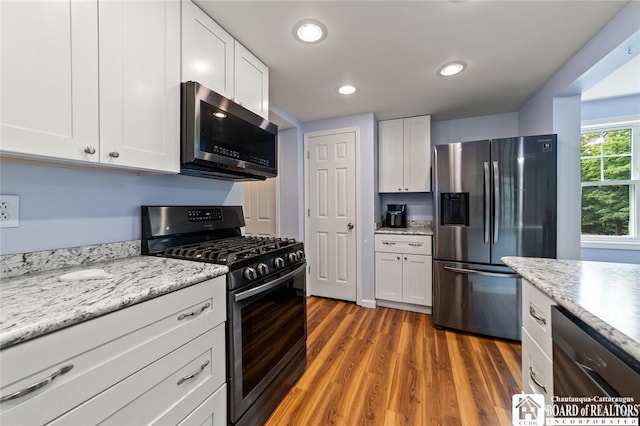 2777 S Roberts Rd, Sheridan, NY 14063 - kitchen with stainless steel appliances, white cabinets, wood finished floors, light stone counters, and recessed lighting
