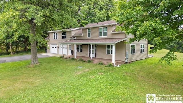 2777 S Roberts Rd, Sheridan, NY 14063 - view of front of house with a porch, a garage, asphalt driveway, and a front lawn