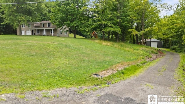 2777 S Roberts Rd, Sheridan, NY 14063 - view of grassy yard featuring an outbuilding, a detached garage, and covered porch