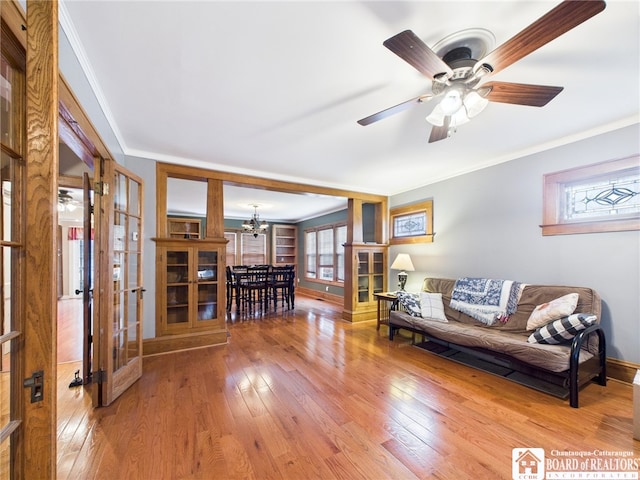 118 N 3rd St, Allegany, NY 14706 - living room with french doors, ornamental molding, light wood finished floors, a chandelier, and a ceiling fan