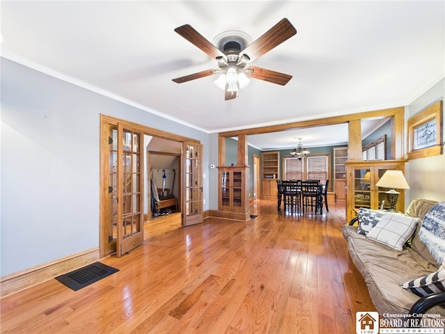 118 N 3rd St, Allegany, NY 14706 - living room featuring french doors, a chandelier, crown molding, wood finished floors, and a ceiling fan