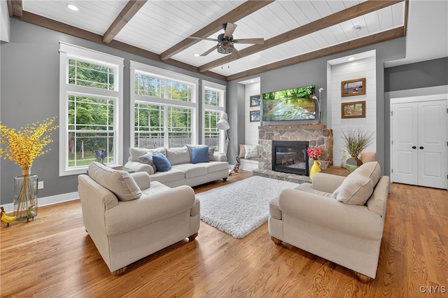 8873 Salvatore Ave, Lysander, NY 13027 - living area featuring a wooden ceiling with exposed beams, a stone fireplace, ceiling fan, and light wood-style flooring