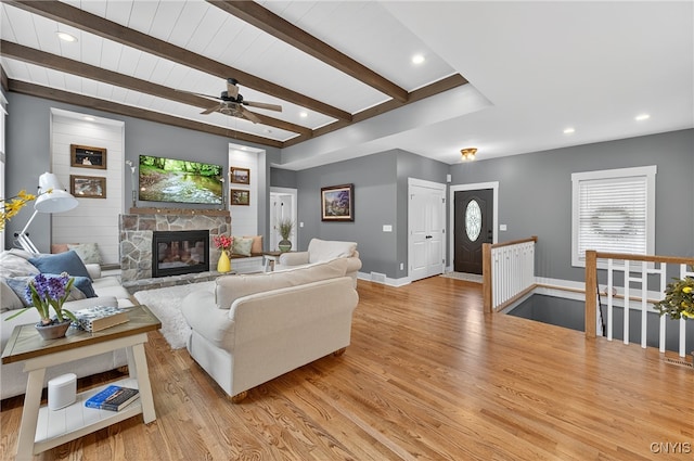 8873 Salvatore Ave, Lysander, NY 13027 - living area with light wood-type flooring, a fireplace, a ceiling fan, beam ceiling, and healthy amount of natural light