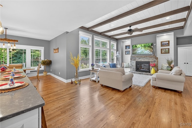 8873 Salvatore Ave, Lysander, NY 13027 - living area featuring light wood finished floors, ceiling fan, a stone fireplace, healthy amount of natural light, and a wood ceiling with exposed beams
