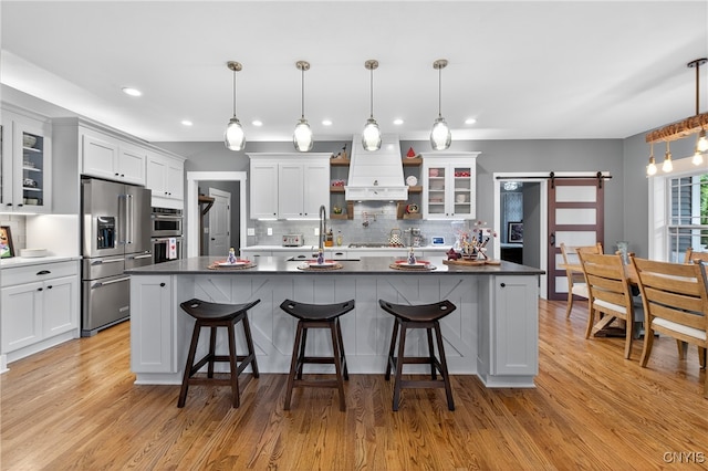 8873 Salvatore Ave, Lysander, NY 13027 - kitchen with high quality fridge, a barn door, premium range hood, dark countertops, and recessed lighting