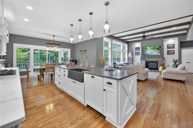8873 Salvatore Ave, Lysander, NY 13027 - kitchen with a stone fireplace, light wood-type flooring, ceiling fan, white cabinets, and recessed lighting
