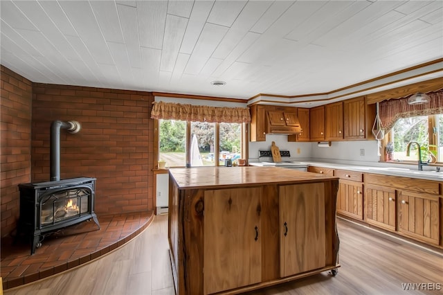2610 Coomer Rd, Newfane, NY 14028 - kitchen featuring custom range hood, white electric range oven, a wood stove, a center island, and light wood-style flooring