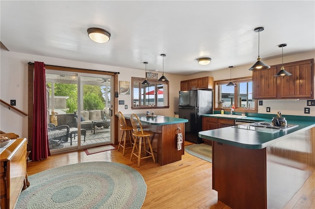 5041 Mapes Mathews Rd, Hector, NY 14818 - kitchen featuring freestanding refrigerator, a peninsula, a breakfast bar area, and healthy amount of natural light