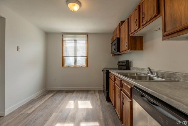 8405 Winterberry Way, Clay, NY 13090 - kitchen featuring black appliances, brown cabinetry, light wood-style floors, and light countertops