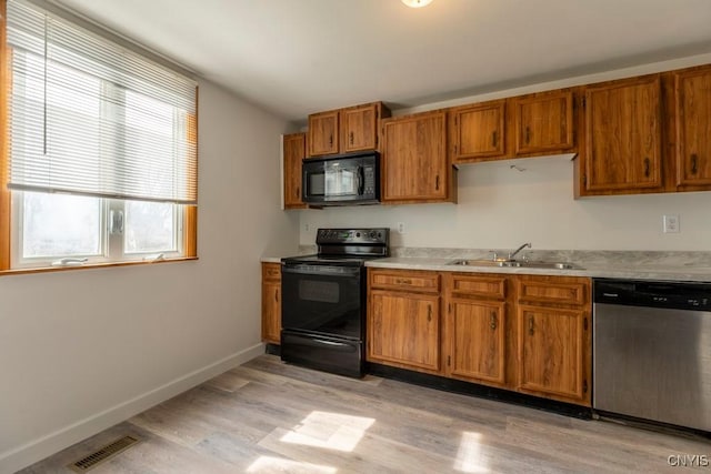 8405 Winterberry Way, Clay, NY 13090 - kitchen with black appliances, brown cabinets, light wood-style floors, and light countertops