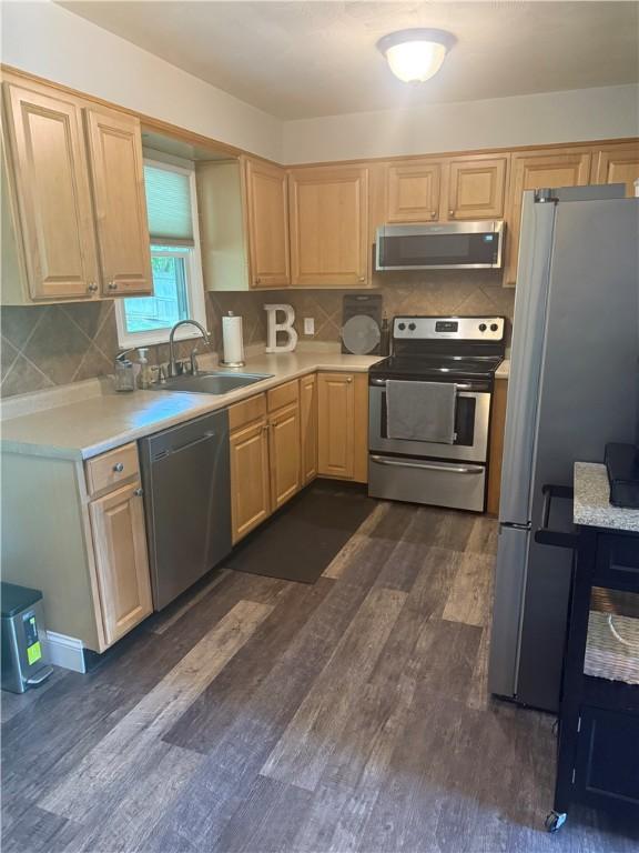 82 Winsor Cir, Elmira, NY 14905 - kitchen with stainless steel appliances, light brown cabinetry, light countertops, dark wood-style flooring, and backsplash