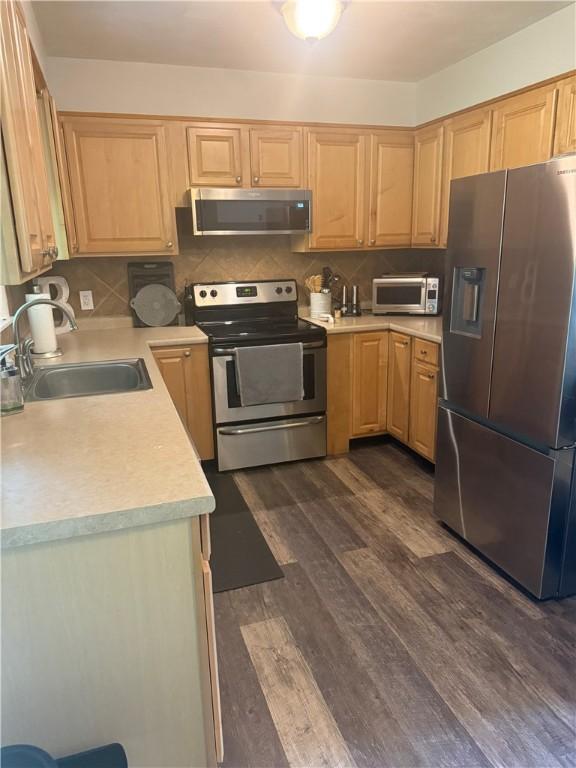 82 Winsor Cir, Elmira, NY 14905 - kitchen featuring stainless steel appliances, light brown cabinets, light countertops, dark wood-style floors, and decorative backsplash