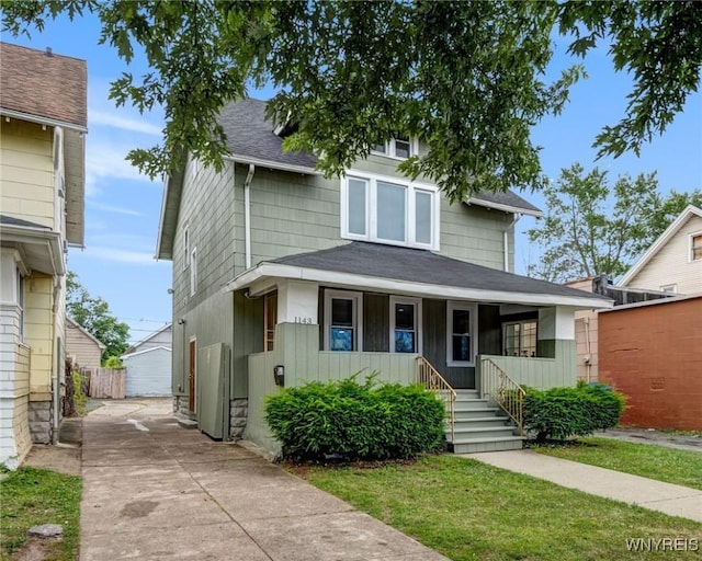 1143 Kensington Ave, Buffalo, NY 14215 - american foursquare style home with covered porch, roof with shingles, and board and batten siding