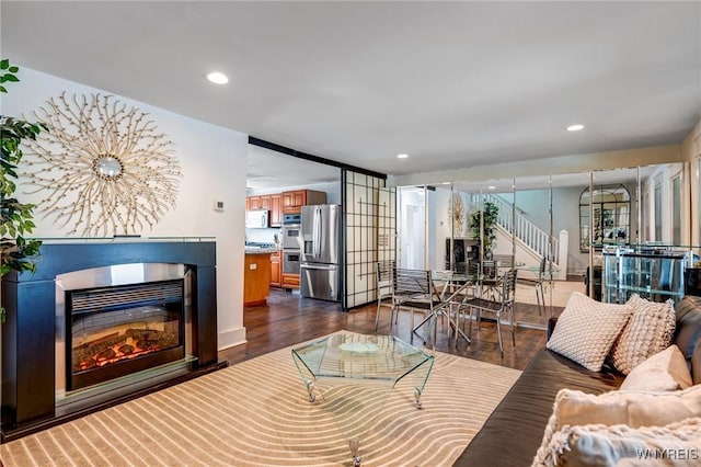 1143 Kensington Ave, Buffalo, NY 14215 - living room with dark wood-style floors, a glass covered fireplace, stairway, and recessed lighting