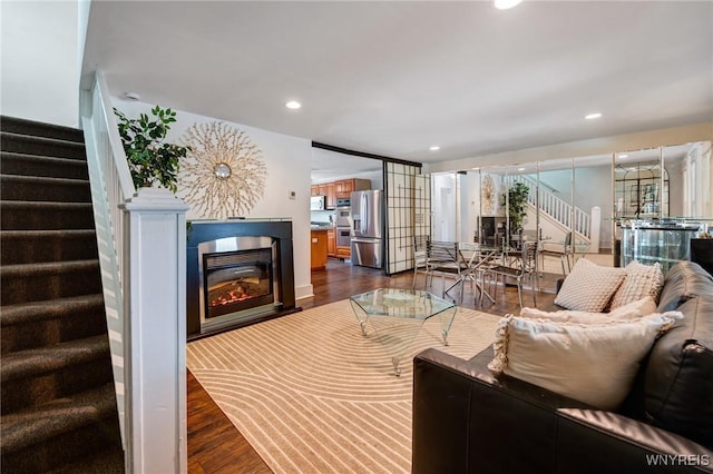 1143 Kensington Ave, Buffalo, NY 14215 - living room with stairway, dark wood-style floors, a glass covered fireplace, and recessed lighting
