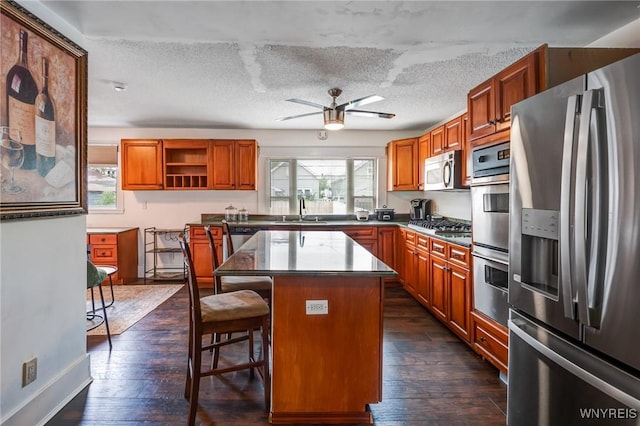 1143 Kensington Ave, Buffalo, NY 14215 - kitchen featuring stainless steel appliances, healthy amount of natural light, brown cabinetry, and a textured ceiling