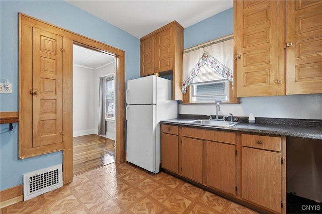 345 Wayland Rd, Salina, NY 13208 - kitchen featuring freestanding refrigerator, dark countertops, brown cabinetry, and crown molding
