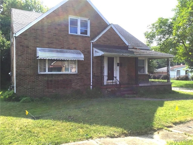 25 Fernwood Ave, West Seneca, NY 14206 - view of front facade with brick siding, covered porch, a front yard, and roof with shingles