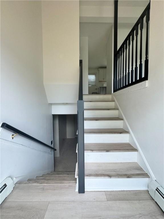 12017 Birch Dr, Corning, NY 14830 - stairs with a baseboard heating unit and wood finished floors