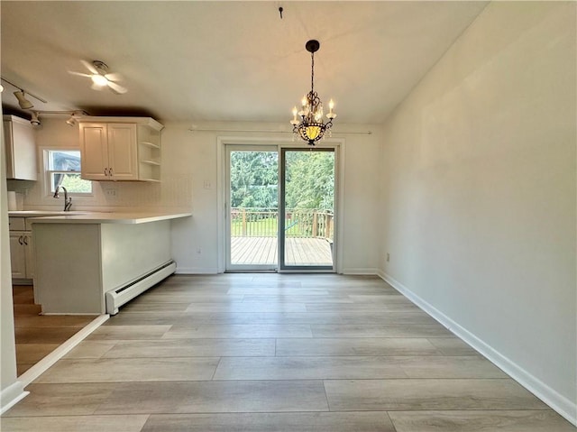 12017 Birch Dr, Corning, NY 14830 - kitchen with baseboard heating, light countertops, a chandelier, light wood finished floors, and open shelves