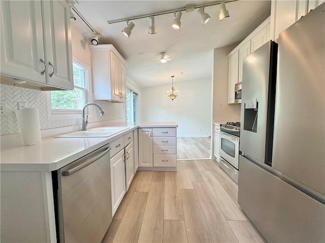 12017 Birch Dr, Corning, NY 14830 - kitchen featuring stainless steel appliances, light wood-style floors, a peninsula, tasteful backsplash, and white cabinetry