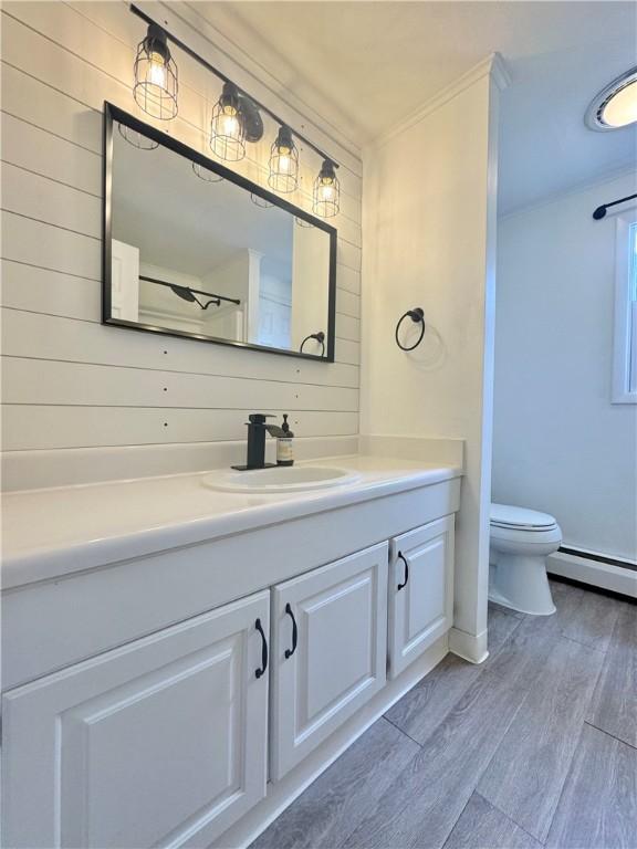 12017 Birch Dr, Corning, NY 14830 - full bathroom featuring vanity, wood finished floors, and a baseboard heating unit